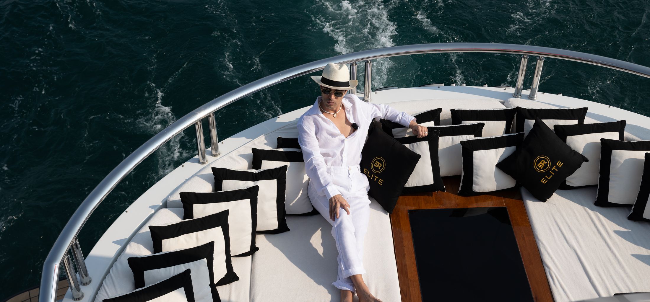 A guest on the bow of a crewed charter yacht at sea